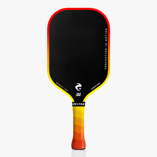 A high-performance pickleball paddle featuring a black surface framed by a fiery red-to-yellow gradient. The handle, styled with matching hues, displays 